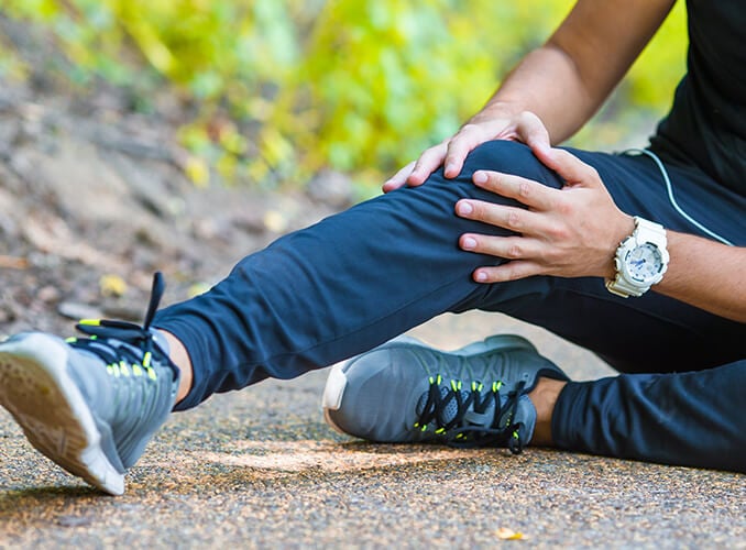 man holding knee on the ground