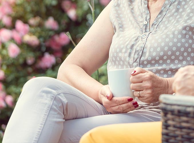 focus on knee - woman enjoying coffee