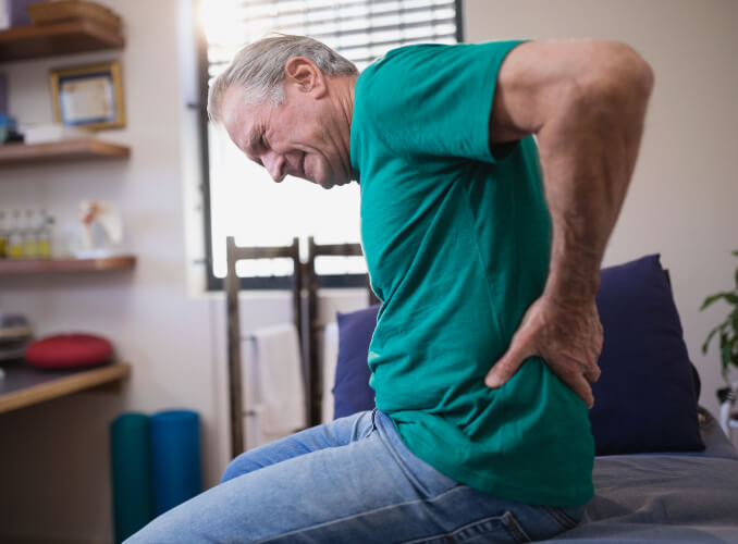 man holding back in pain